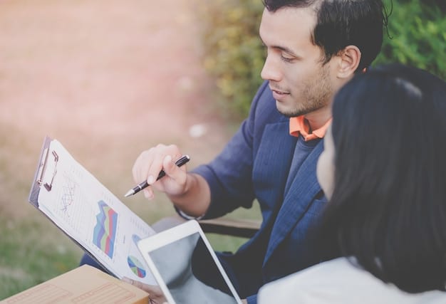 A person holding a pen and reviewing a printed report of their spending habits. The report is filled with numbers, charts, and graphs, highlighting the person's financial data.