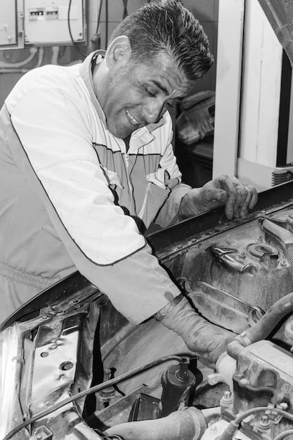 A mechanic working on a car engine, with various tools scattered around, emphasizing the potential for unexpected auto repair expenses.