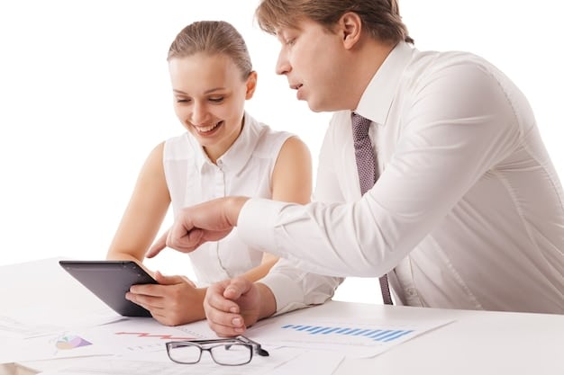 A man and woman sitting at a table, reviewing investment performance charts on a tablet with a financial advisor. They are smiling and engaged, symbolizing confident and informed financial decision-making.